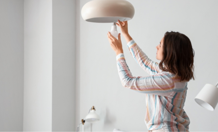 woman changing light bulb